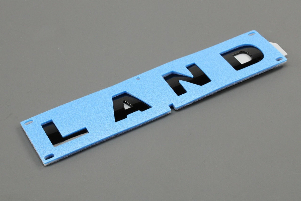 Land Rover Defender 2007-2016 'LAND' badge emblem (front) VPLDB0131, view 1